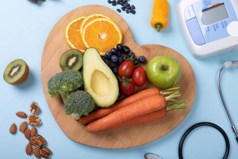 Overhead view of vegetables and fruits on heart shaped board over blue background, copy space. unaltered, food, organic, wellness and healthy eating concept.