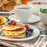 Fresh pancakes with raspberries, blueberries and honey