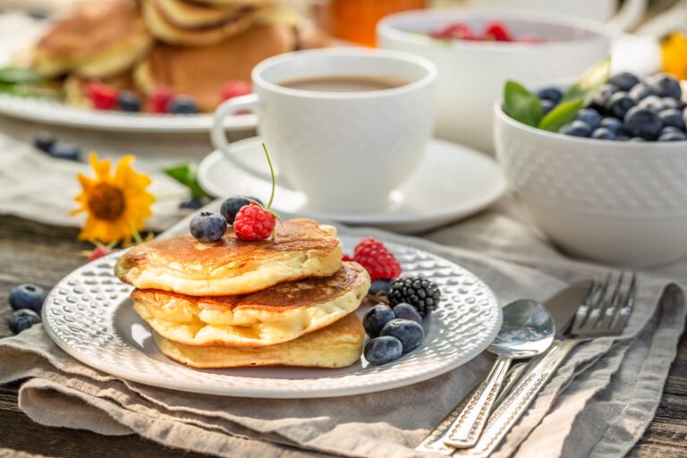 Fresh pancakes with raspberries, blueberries and honey